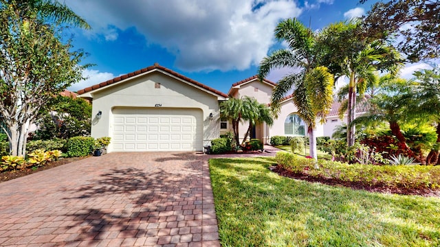 mediterranean / spanish-style home featuring a garage and a front yard