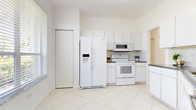 kitchen featuring tasteful backsplash, white cabinets, white appliances, and light tile patterned flooring