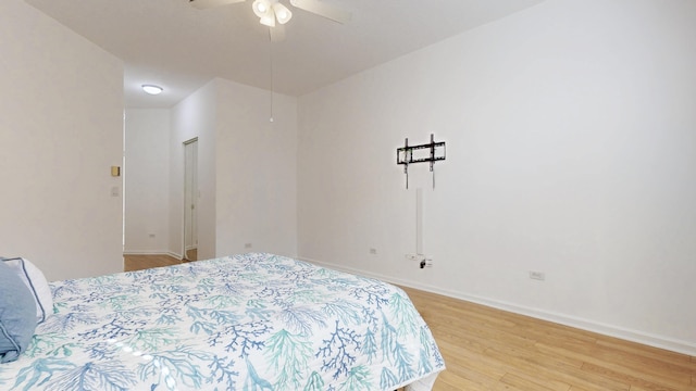 bedroom with ceiling fan, baseboards, and wood finished floors