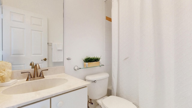 bathroom with curtained shower, toilet, and vanity