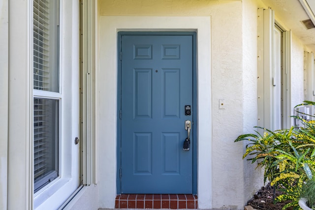 view of exterior entry featuring stucco siding