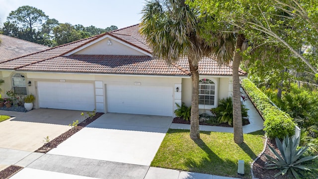 view of front of home with stucco siding, a garage, concrete driveway, and a tile roof