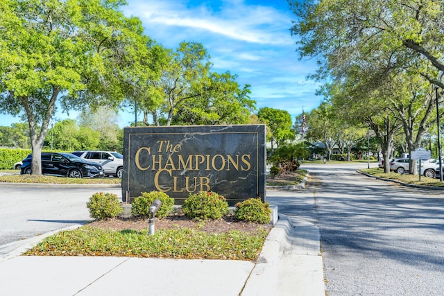 community / neighborhood sign featuring uncovered parking