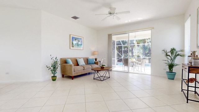 living area featuring visible vents, light tile patterned flooring, a sunroom, baseboards, and ceiling fan