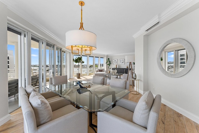 dining space featuring crown molding and light hardwood / wood-style floors