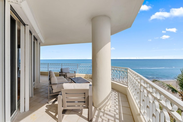 balcony featuring a water view and a beach view