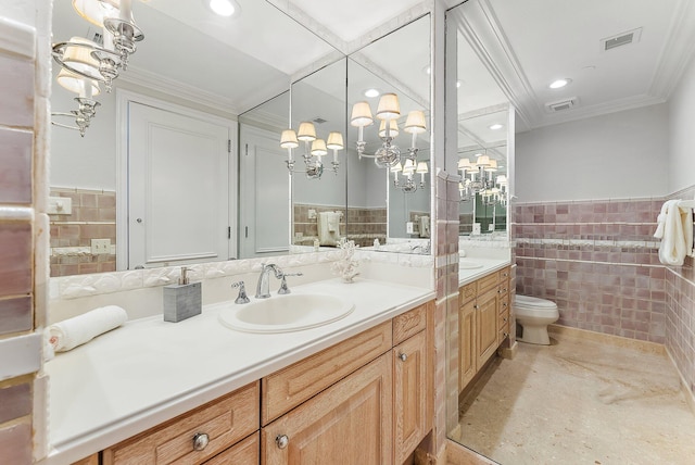 bathroom with tile walls, tile patterned flooring, vanity, toilet, and crown molding