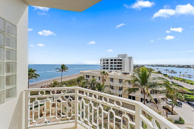 balcony featuring a water view and a beach view