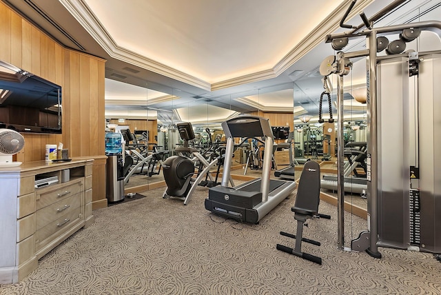 gym with ornamental molding and a raised ceiling