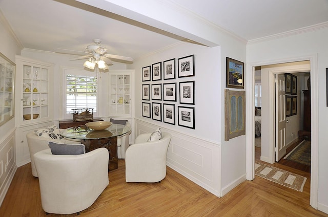 dining room featuring ornamental molding, a decorative wall, and ceiling fan