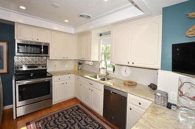 kitchen with stainless steel appliances, a sink, visible vents, white cabinetry, and light wood finished floors