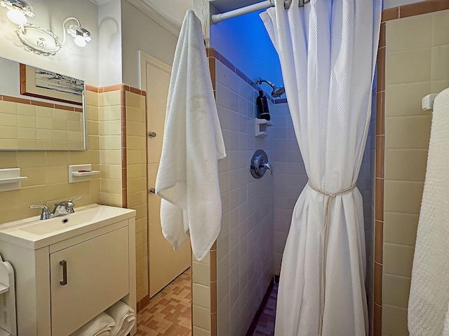 full bath with vanity, tile walls, and tiled shower