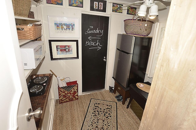 kitchen with freestanding refrigerator, electric cooktop, and white microwave