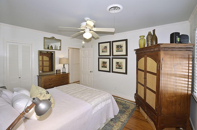 bedroom featuring ornamental molding, a ceiling fan, visible vents, and wood finished floors