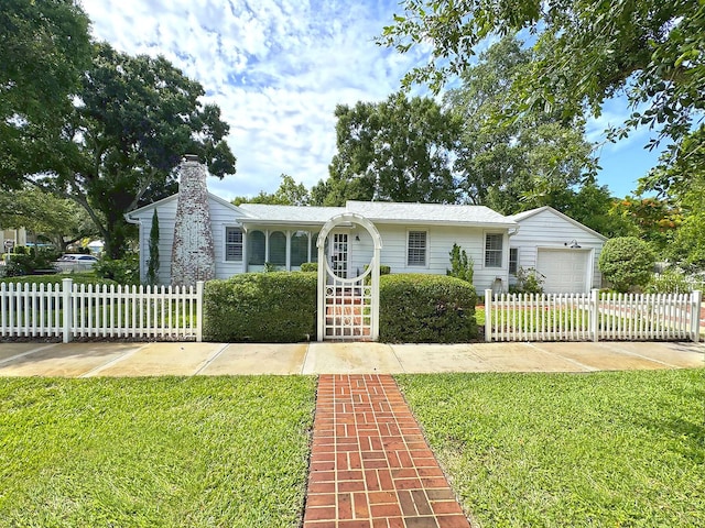 view of front of home with a garage, a fenced front yard, a chimney, and a front lawn