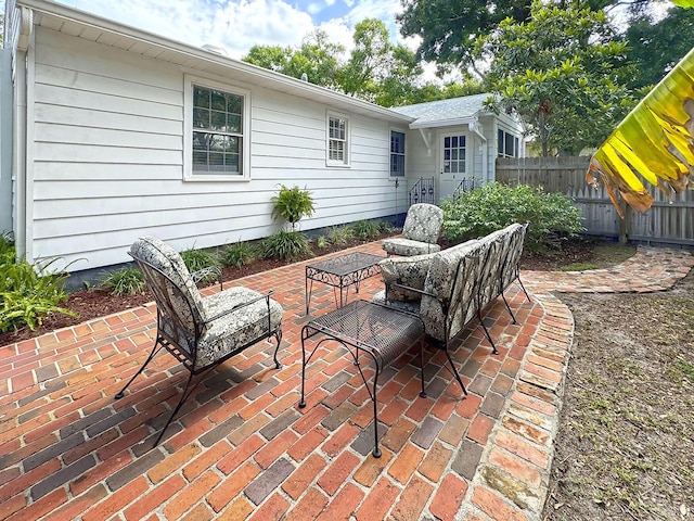 view of patio featuring outdoor lounge area and fence