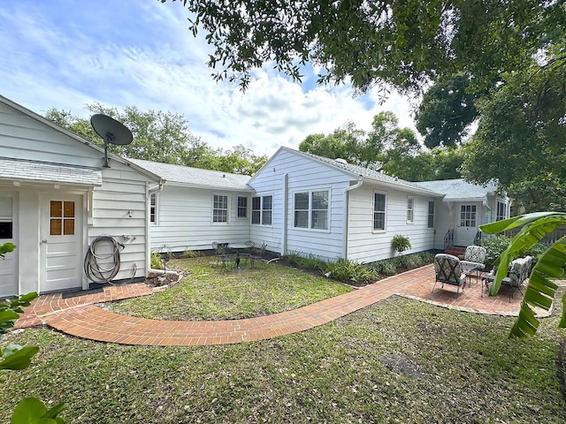 rear view of property with a patio area and a yard