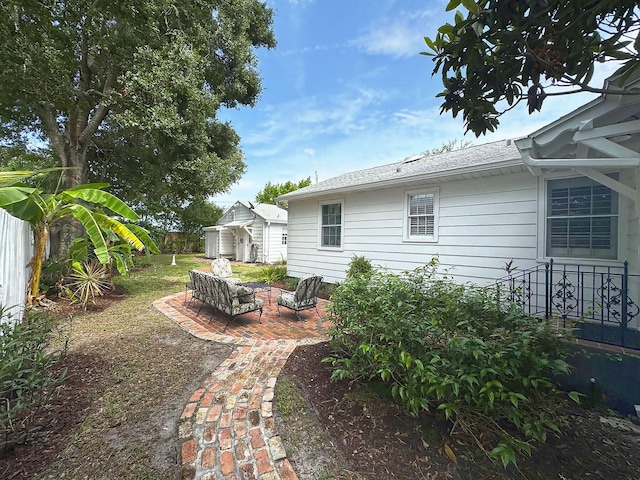 view of yard featuring an outbuilding, a patio, and fence