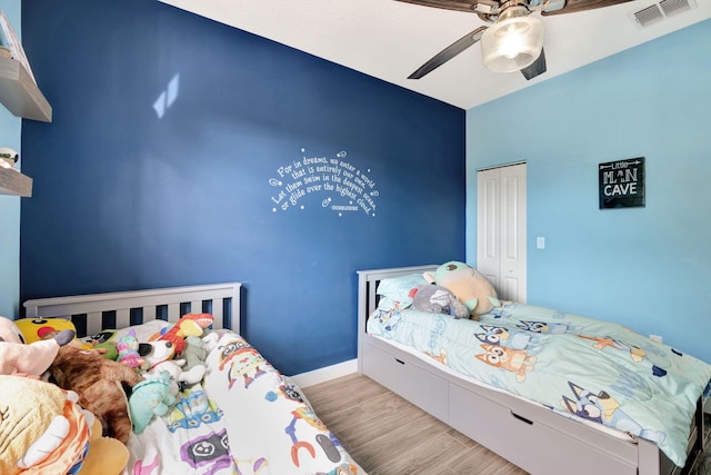 bedroom featuring ceiling fan, light hardwood / wood-style floors, and a closet