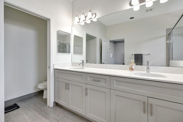 bathroom with vanity, walk in shower, and toilet