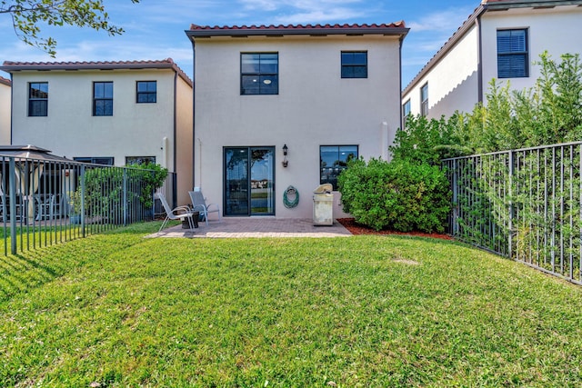 rear view of house with a lawn and a patio area