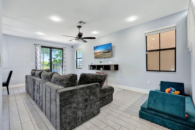 living room with a textured ceiling and ceiling fan