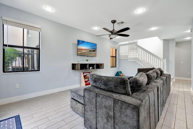 living room with a textured ceiling and ceiling fan