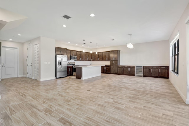 kitchen with wine cooler, decorative light fixtures, dark brown cabinets, a kitchen island, and stainless steel appliances