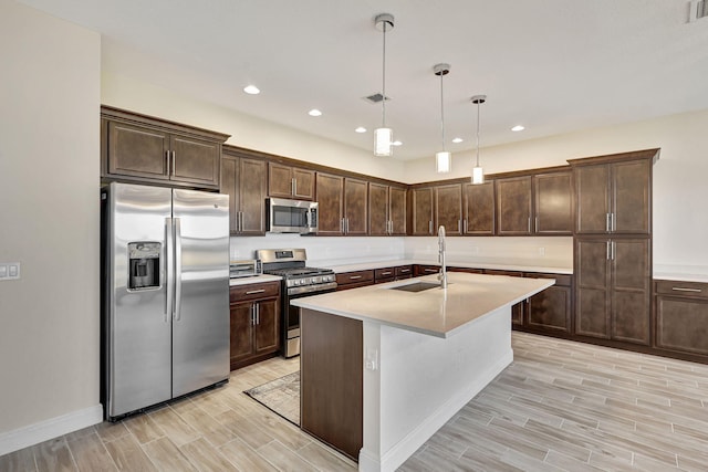 kitchen featuring stainless steel appliances, sink, pendant lighting, and dark brown cabinetry