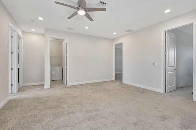 unfurnished bedroom with connected bathroom, washer / dryer, light colored carpet, and ceiling fan