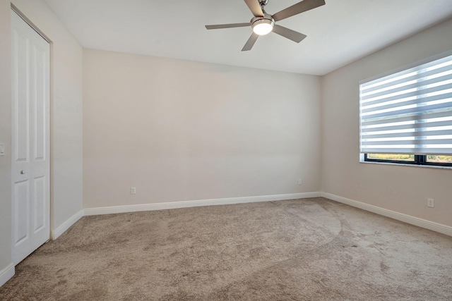 carpeted spare room with ceiling fan