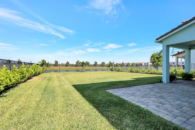 view of yard with a water view and a patio area