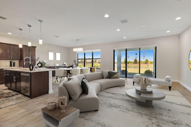 living room with sink and light hardwood / wood-style flooring