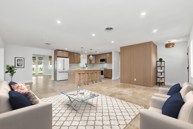 living area featuring recessed lighting, visible vents, and baseboards