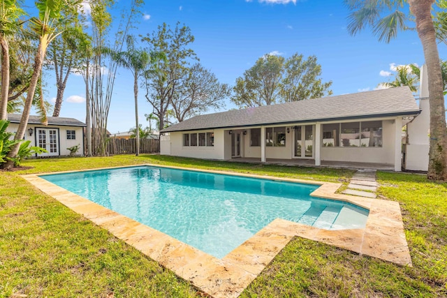 pool at dusk with fence, a fenced in pool, french doors, an outdoor structure, and a yard