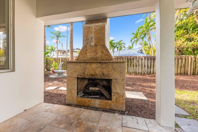 view of patio / terrace featuring fence and a tiled fireplace