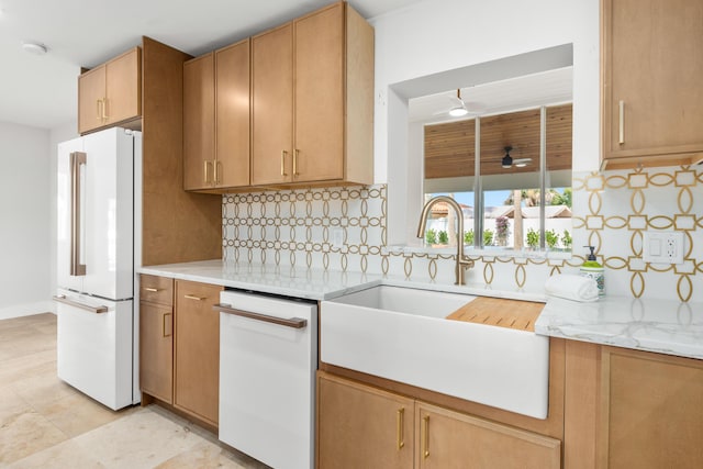 kitchen featuring sink, light stone counters, white appliances, ceiling fan, and decorative backsplash