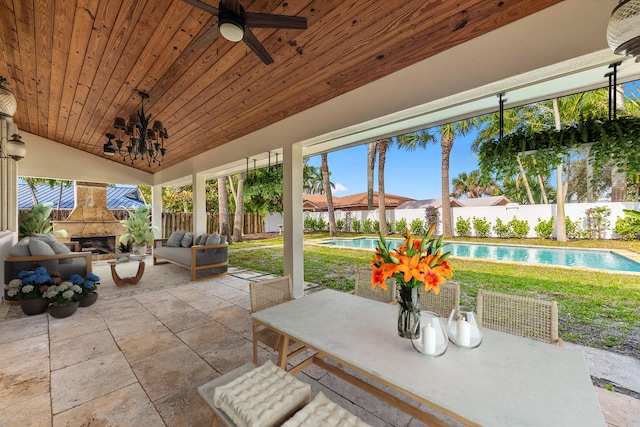 4430 SE Bayshore Ter, Stuart, FL 34997 - fenced backyard with a patio area, outdoor dining area, ceiling fan, and an outdoor living space with a fireplace
