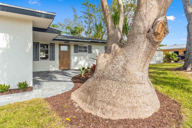 entrance to property with a patio and a lawn