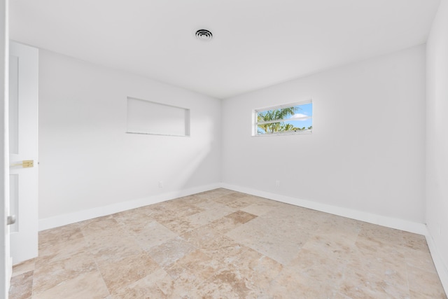 empty room with baseboards and visible vents