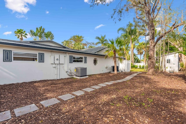 4430 SE Bayshore Ter, Stuart, FL 34997 - back of property featuring stucco siding, central AC unit, and a shingled roof