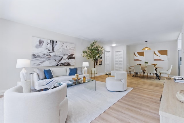 living area featuring baseboards and light wood finished floors