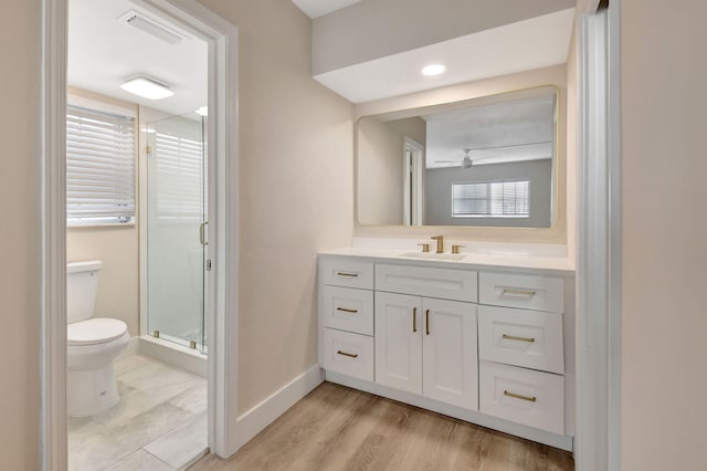 full bath with toilet, visible vents, vanity, baseboards, and a shower stall