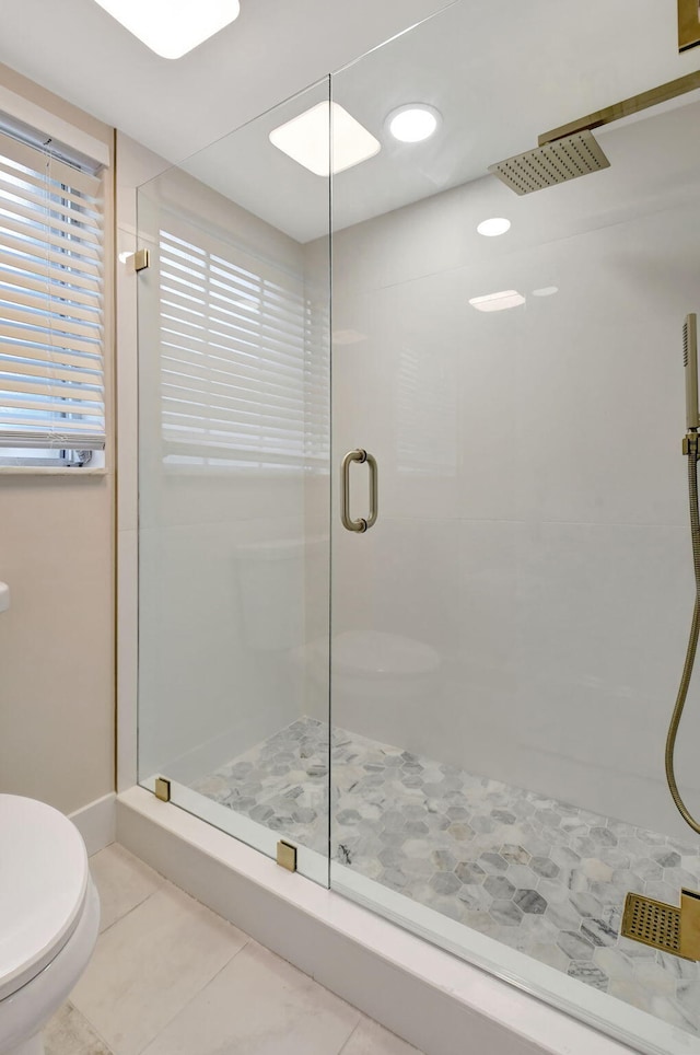 full bathroom featuring tile patterned flooring, a shower stall, and toilet