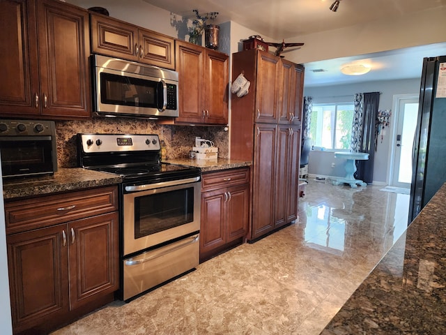 kitchen featuring tasteful backsplash, stainless steel appliances, and dark stone countertops