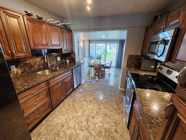 kitchen featuring tasteful backsplash, stainless steel appliances, sink, and dark stone counters