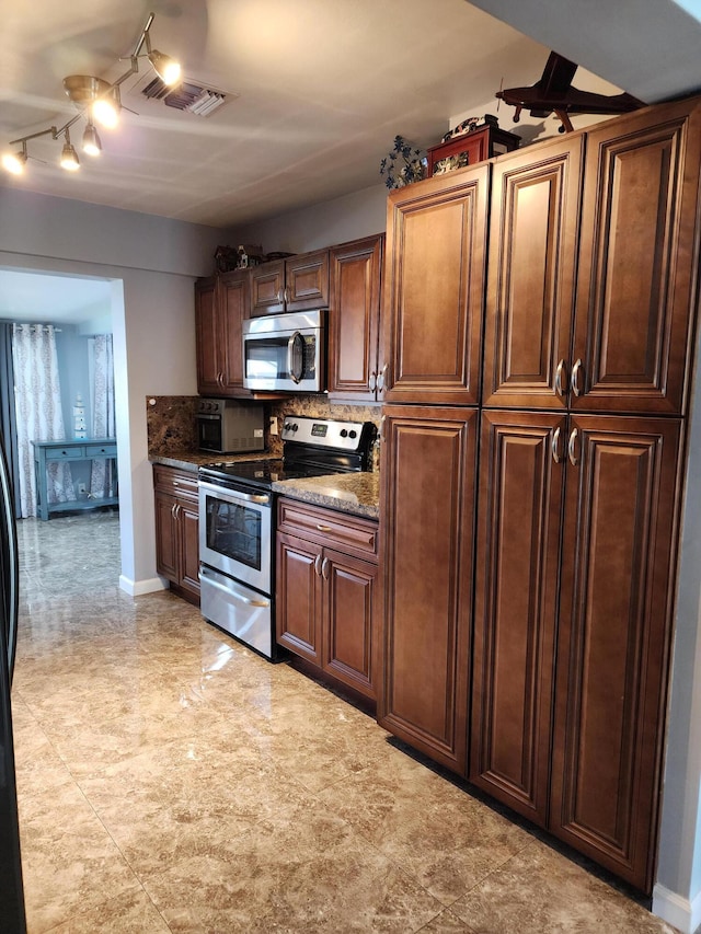 kitchen featuring appliances with stainless steel finishes and dark stone countertops