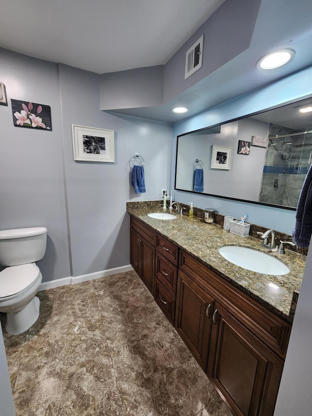 bathroom featuring a shower with door, vanity, and toilet