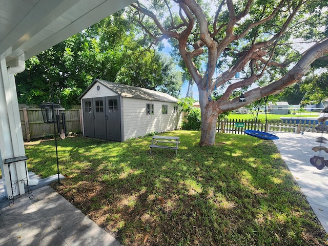 view of yard with a storage shed and a patio