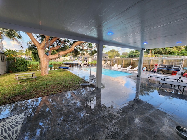 view of pool with a patio and a lawn